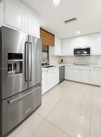 a kitchen with stainless steel appliances a refrigerator sink and cabinets