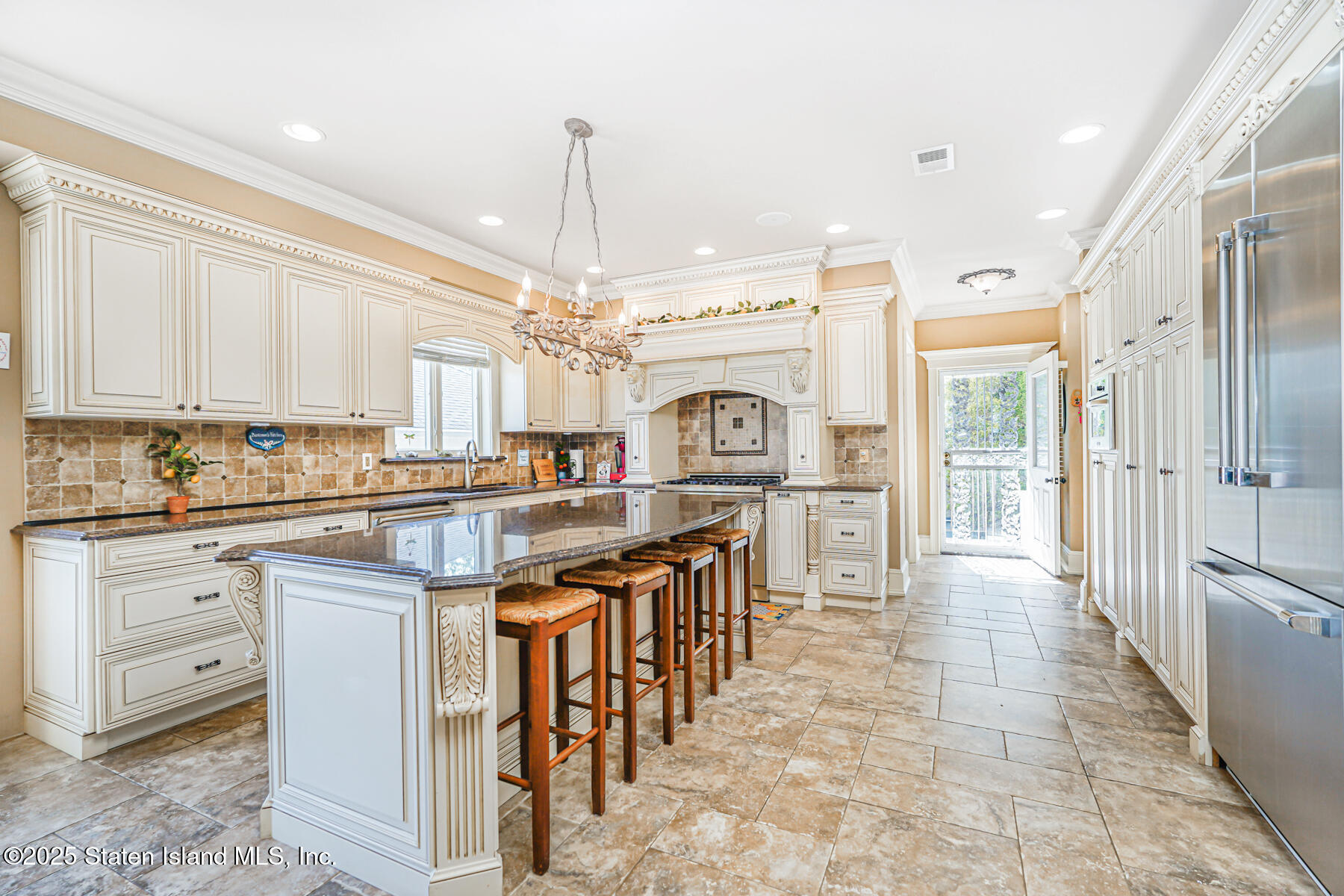 66 Normalee Road Staten Island, NY 10305 - Photo 17 of 54 a kitchen with stainless steel appliances kitchen island granite countertop a table chairs sink and cabinets