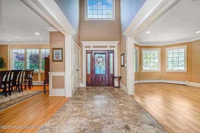 an empty room with wooden floor and natural light