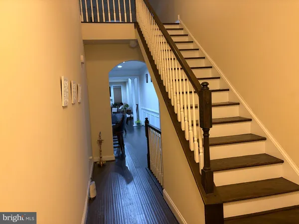a view of staircase with wooden floor and white walls