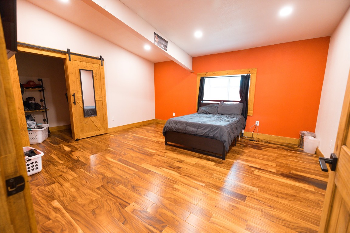 143 County Road Paige, TX 78659 - Photo 17 of 36 a bedroom with a bed and wooden floor