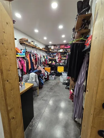 a view of walk in closet with clothes and shoes