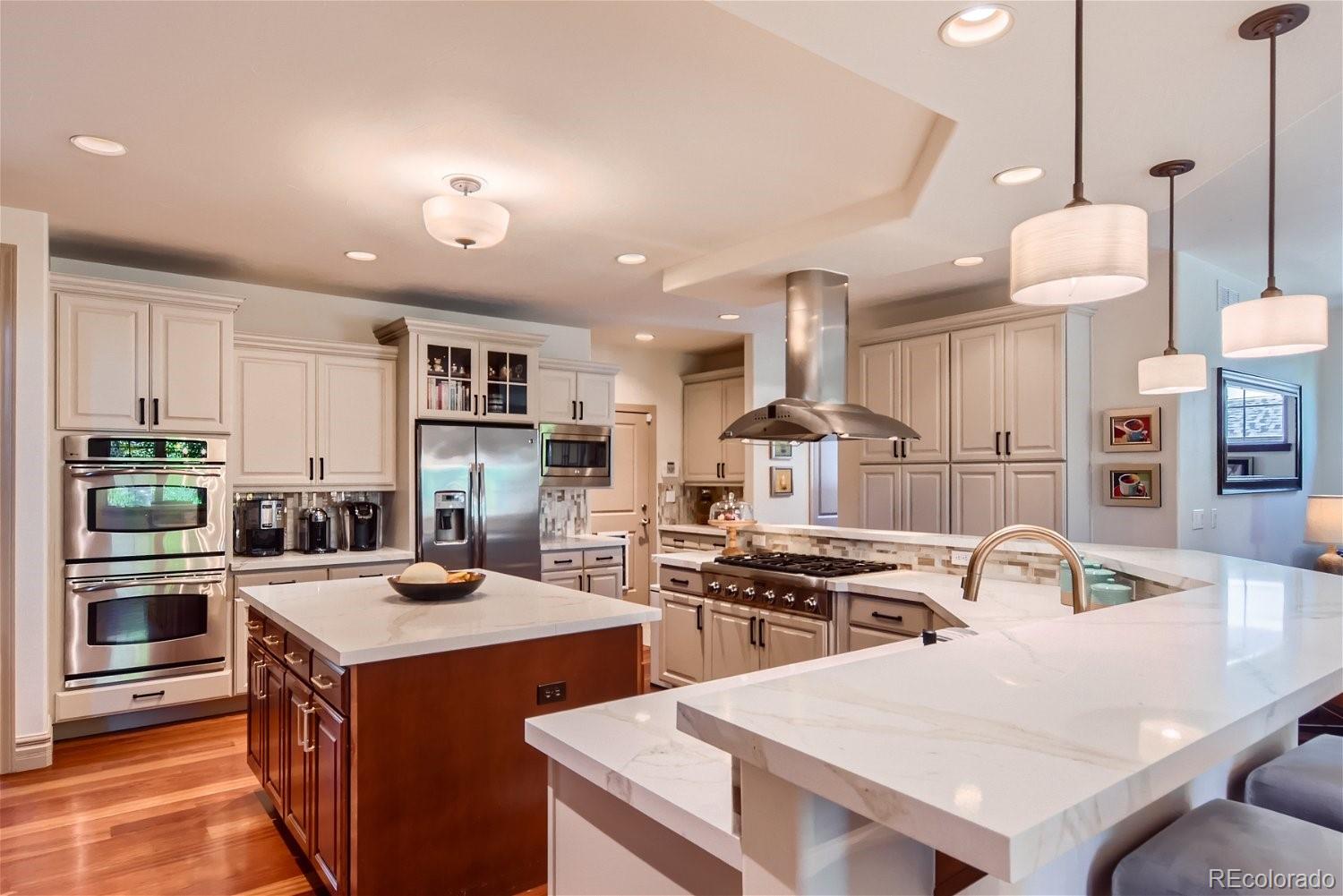 722 Skywalker Point Lafayette, CO 80026 - Photo 11 of 47 a kitchen with a sink a stove and chairs