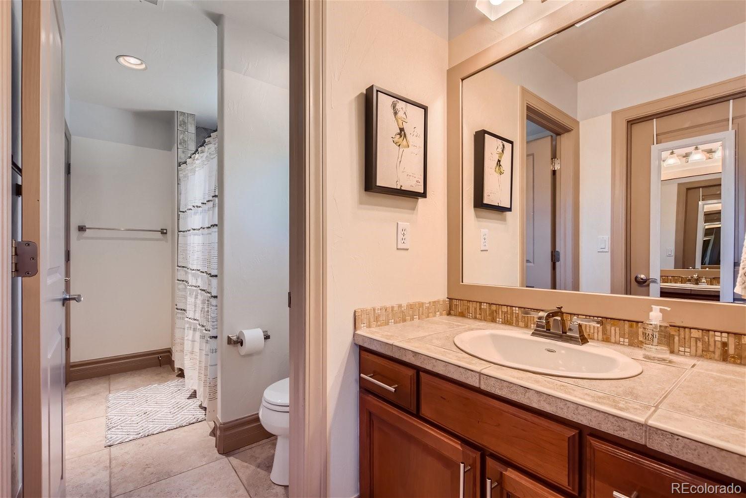 722 Skywalker Point Lafayette, CO 80026 - Photo 18 of 47 a bathroom with a granite countertop sink toilet and shower