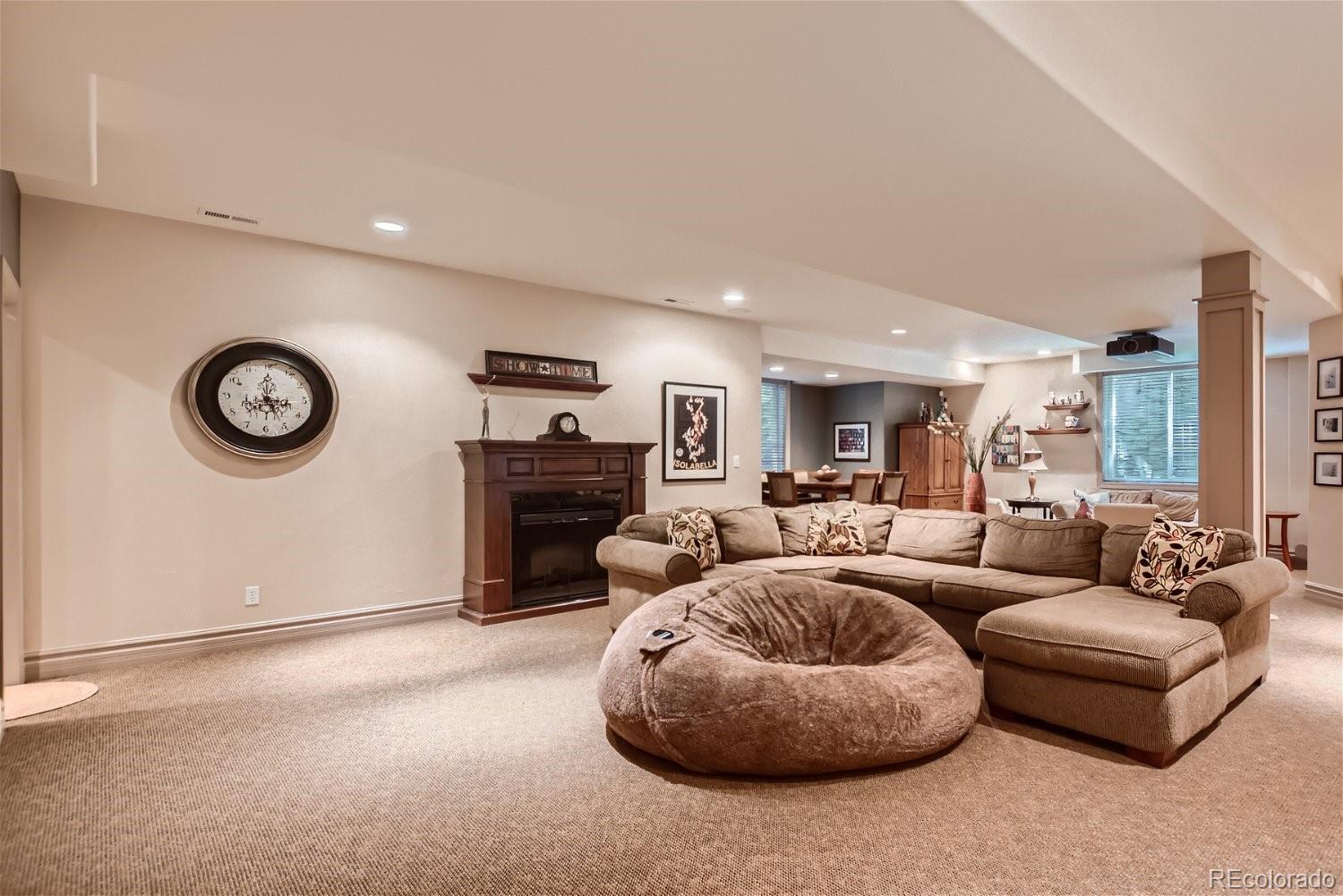 722 Skywalker Point Lafayette, CO 80026 - Photo 32 of 47 a living room with furniture a clock and a large window