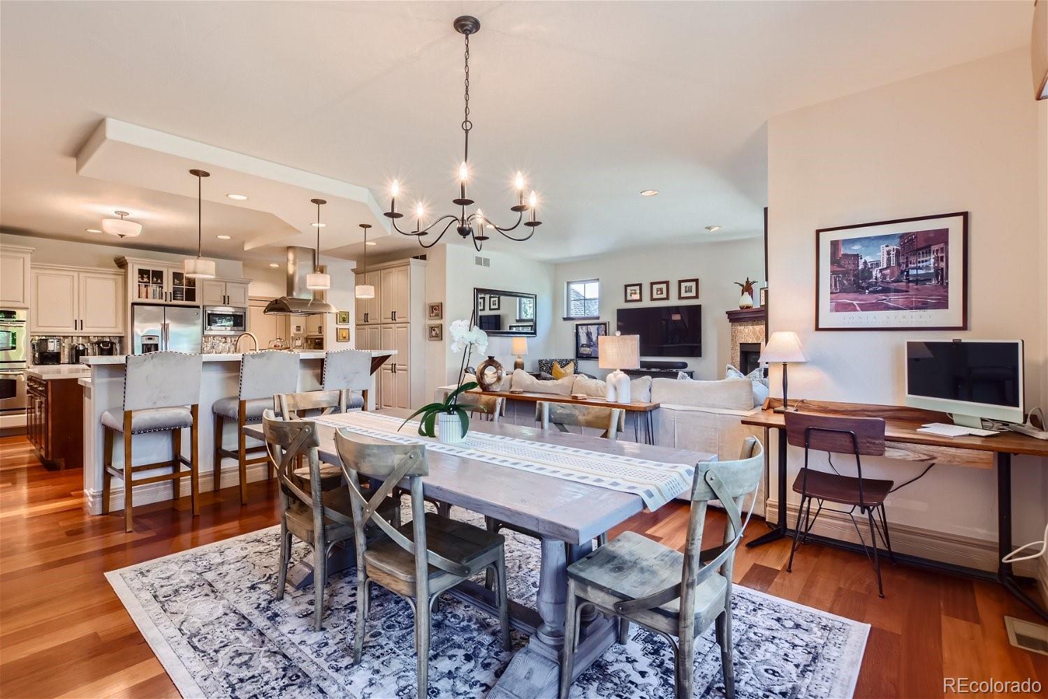 722 Skywalker Point Lafayette, CO 80026 - Photo 9 of 47 a view of a dining room and livingroom with furniture wooden floor a rug a painting and a chandelier