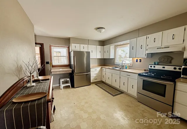 a kitchen with granite countertop a sink stove and refrigerator