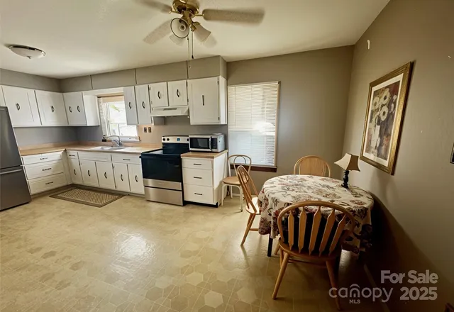 a kitchen with stainless steel appliances granite countertop a sink a stove a refrigerator counter top space and cabinets