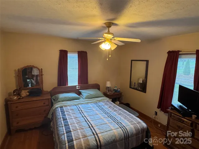 a bedroom with a bed and a flat tv screen on a dresser