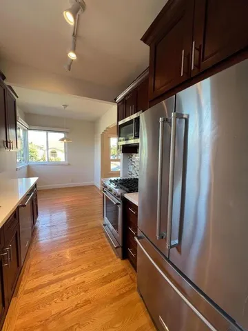 a kitchen with stainless steel appliances granite countertop a refrigerator and a stove