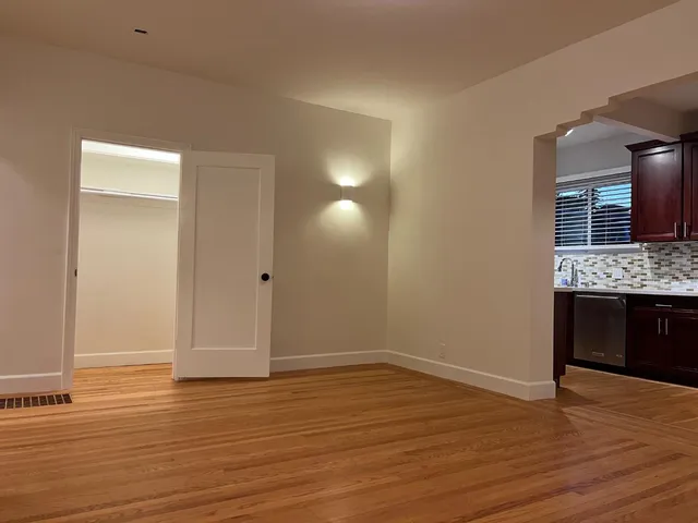 a view of an empty room with wooden floor