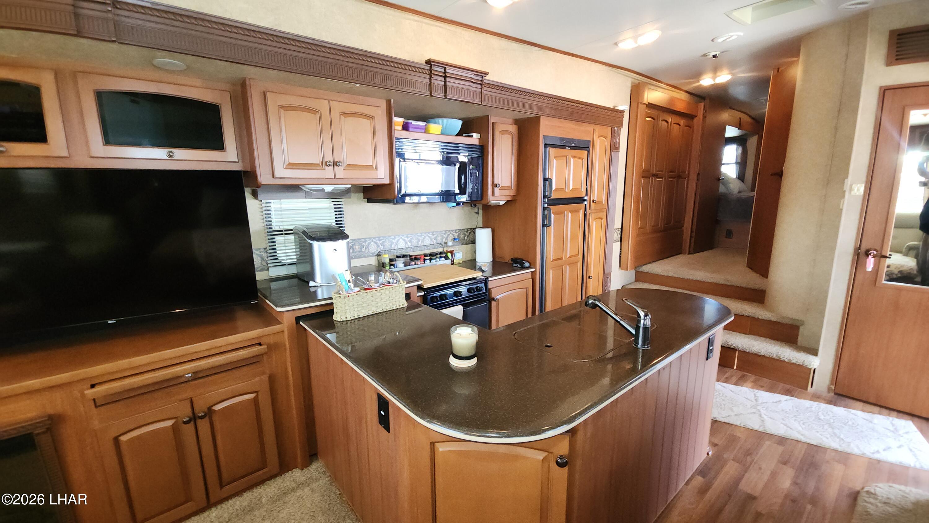 33 North Juniper Road Quartzsite, AZ 85346 - Photo 21 of 40 a kitchen with stainless steel appliances granite countertop a sink refrigerator and cabinets