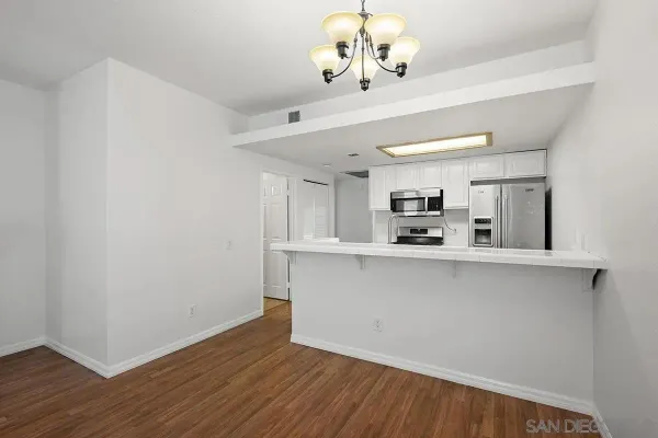 a view of a kitchen with wooden floor and a chandelier