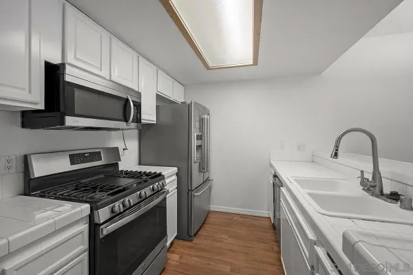 a kitchen with stainless steel appliances a sink stove and microwave