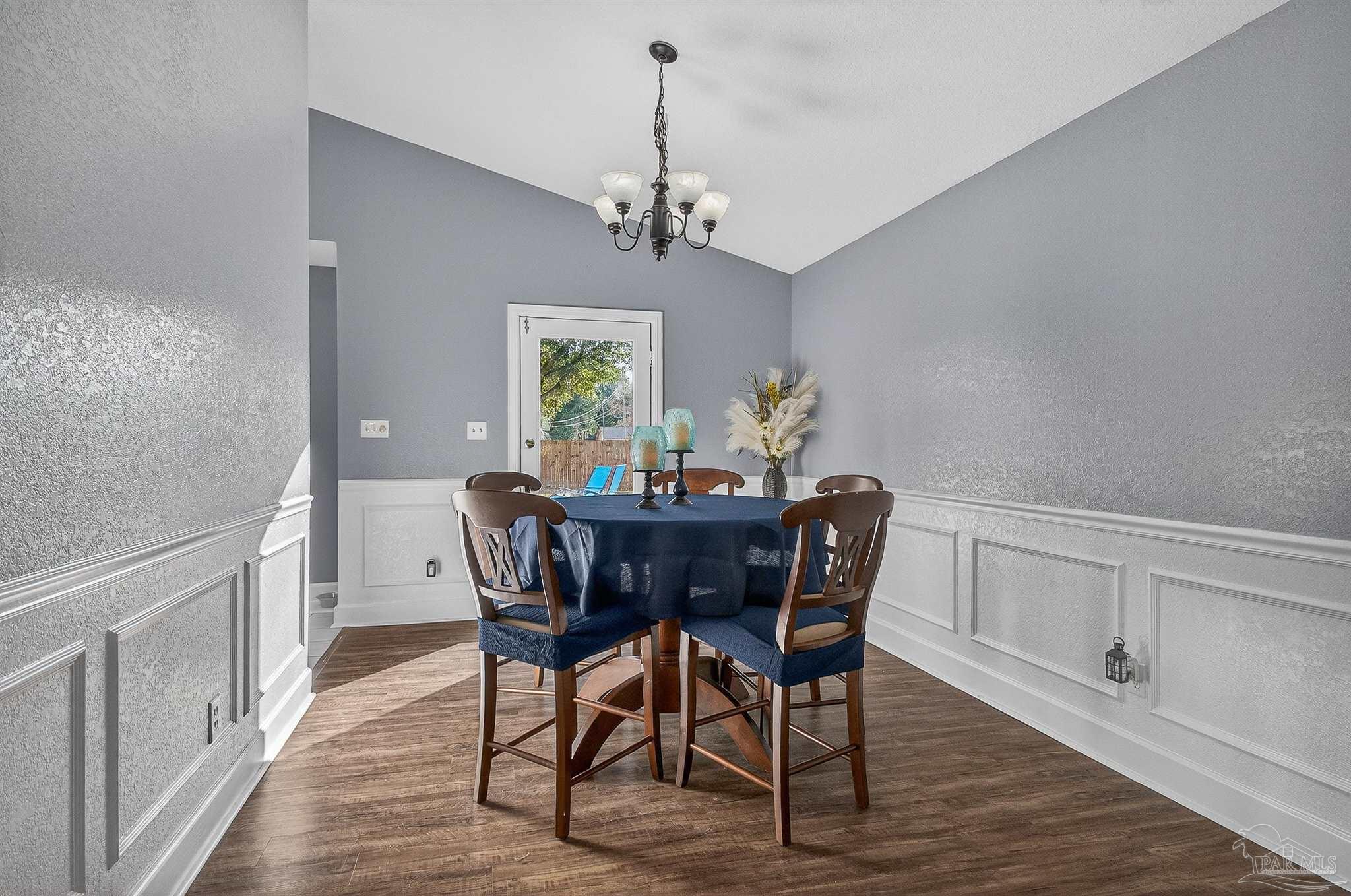 4807 Jennifer Lane Pace, FL 32571 - Photo 12 of 49 a view of a dining room with furniture a chandelier and wooden floor