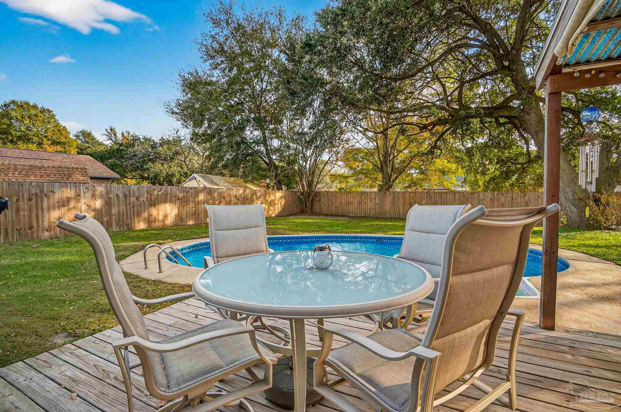 4807 Jennifer Lane Pace, FL 32571 - Photo 46 of 49 a roof deck with table and chairs and potted plants with wooden floor and fence