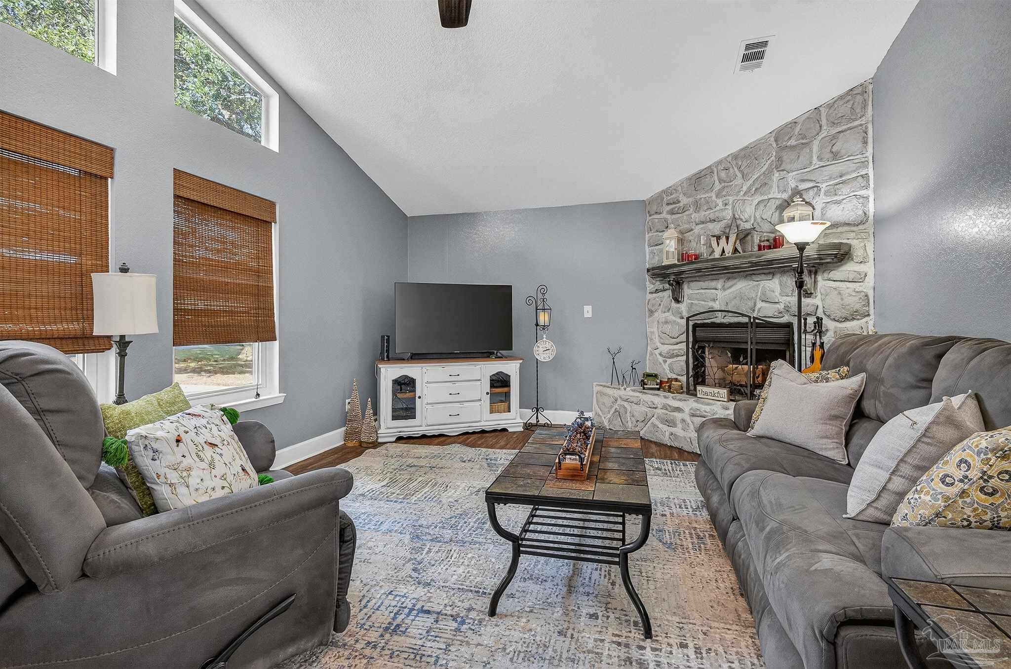 4807 Jennifer Lane Pace, FL 32571 - Photo 7 of 49 a living room with furniture a flat screen tv and a fireplace