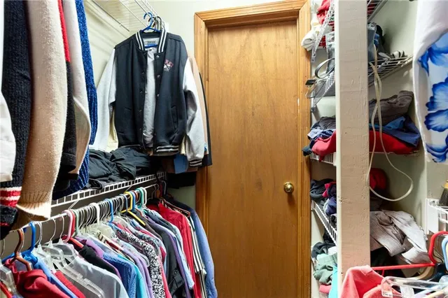 a view of walk in closet with clothes