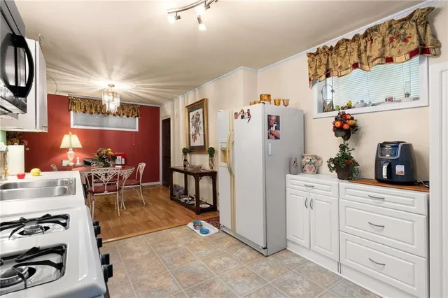 a kitchen with stainless steel appliances granite countertop a refrigerator and a stove top oven