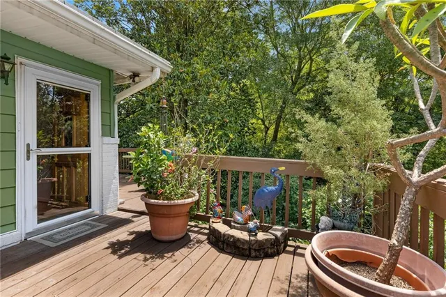 a balcony with table and chairs potted plants with wooden floor