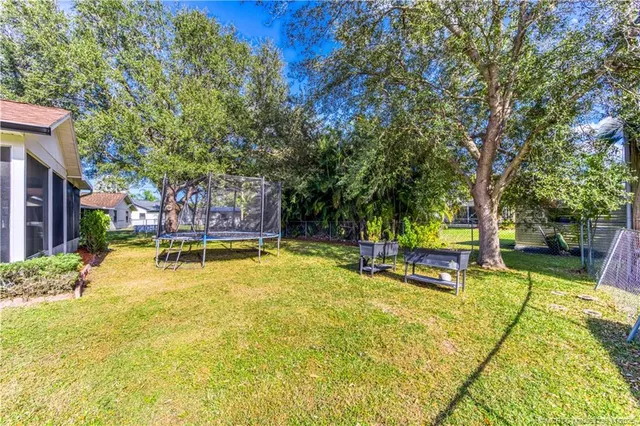 a view of a swimming pool with chairs and trees