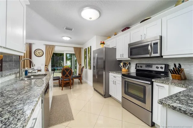 a kitchen with stainless steel appliances granite countertop a stove refrigerator and microwave