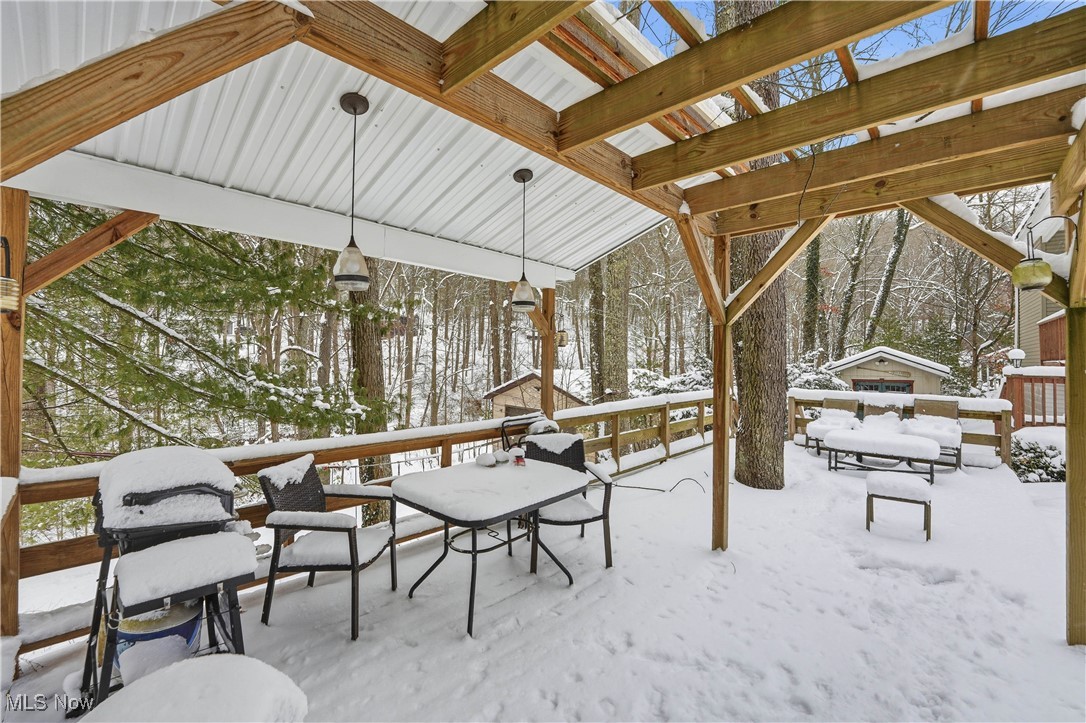 4254 Doral Road Southwest Carrollton, OH 44615 - Photo 16 of 46 Snow covered patio featuring a deck, grilling area, and outdoor dining space
