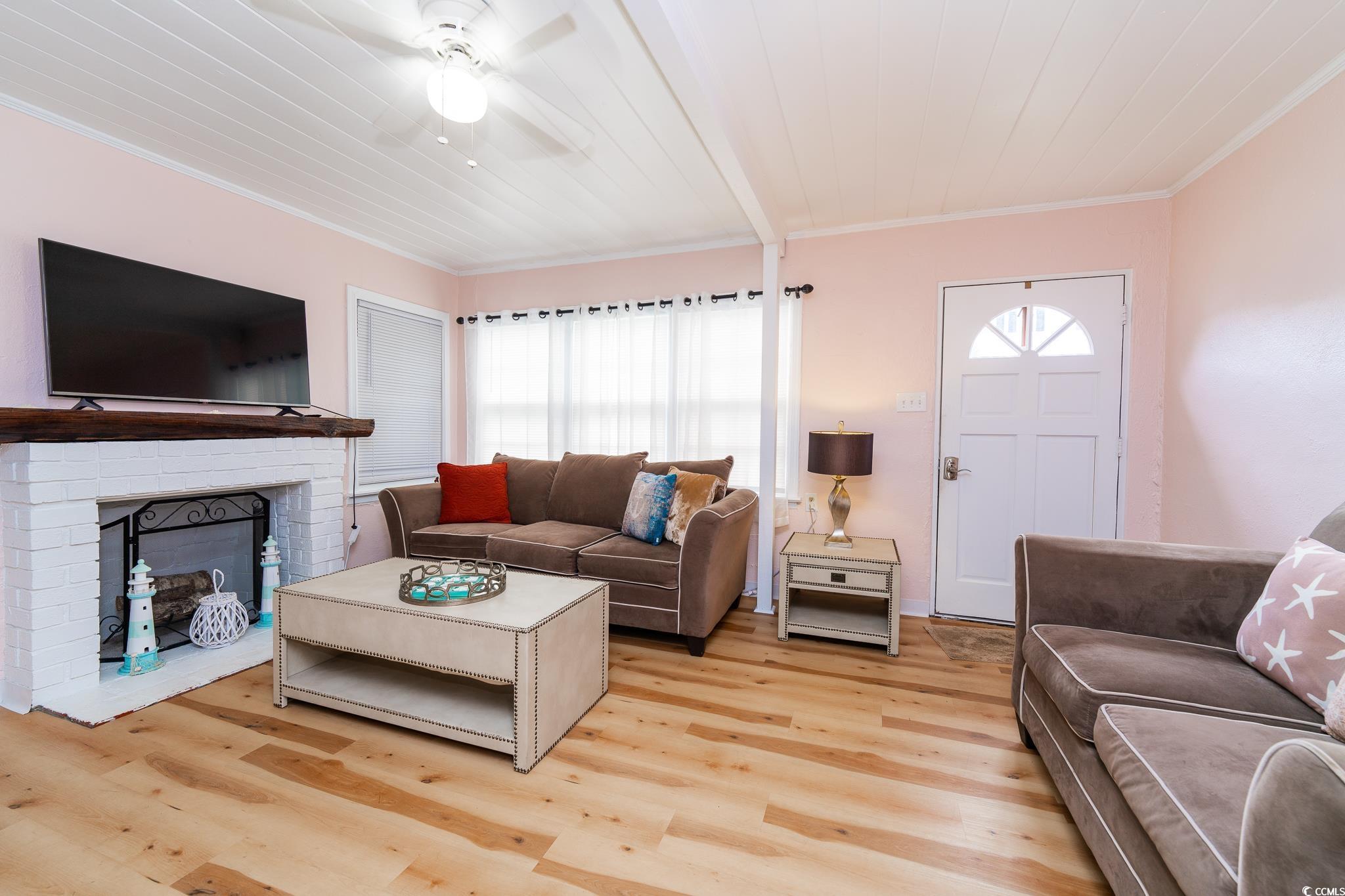 114 North Pinewood Drive Surfside Beach, SC 29575 - Photo 20 of 40 Living room featuring plenty of natural light, crown molding, and light hardwood / wood-style flooring