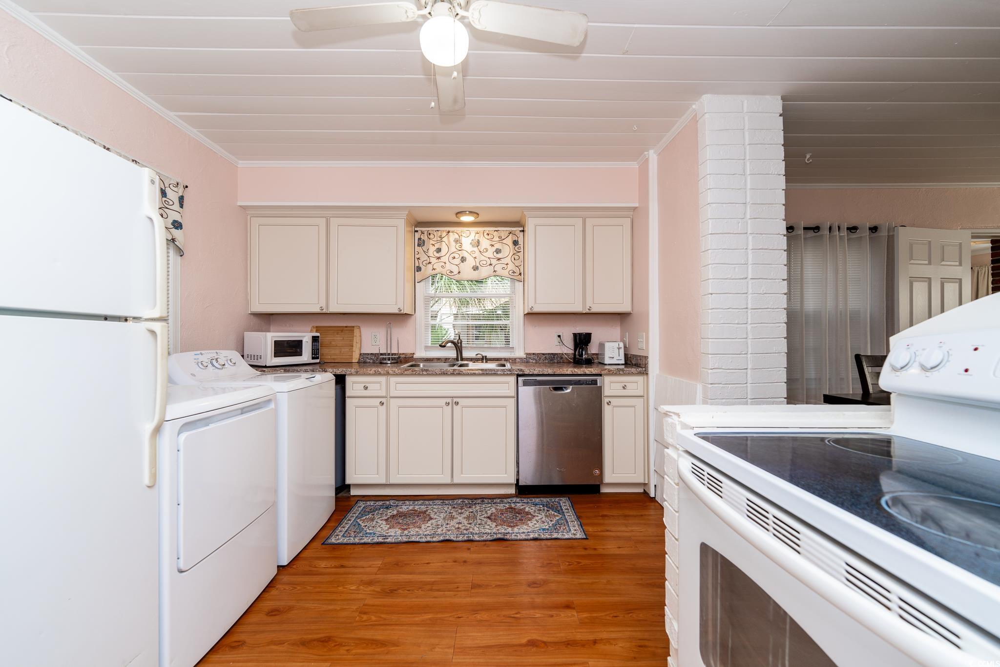 114 North Pinewood Drive Surfside Beach, SC 29575 - Photo 31 of 40 Kitchen featuring sink, crown molding, white appliances, white cabinets, and hardwood / wood-style flooring