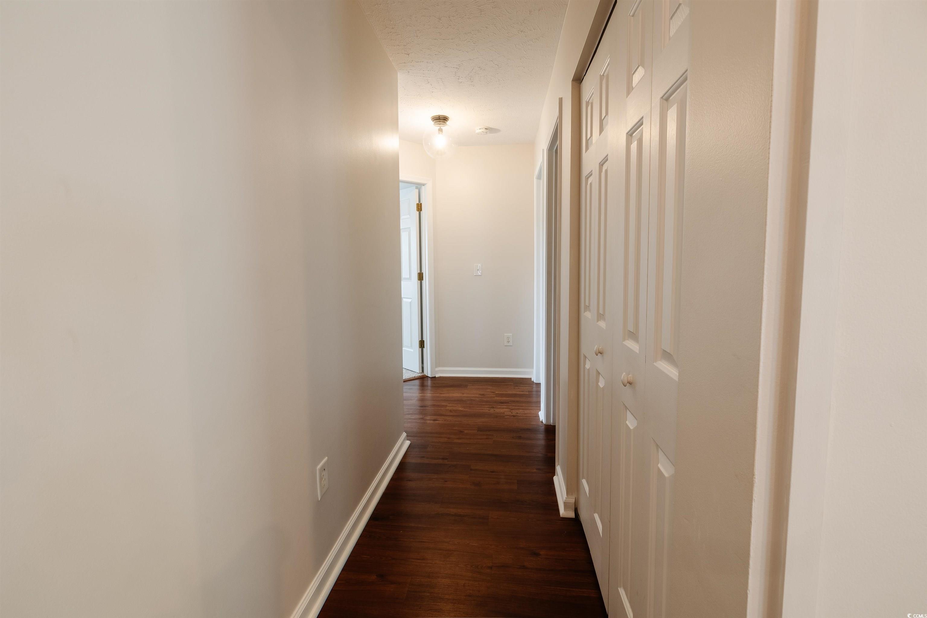 6043 Quinn Road Myrtle Beach, SC 29579 - Photo 13 of 27 Corridor featuring a textured ceiling and dark woo