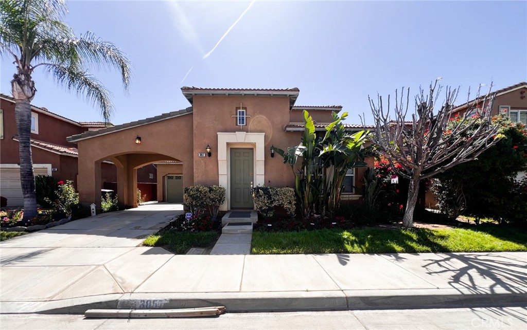 a view of a house with a yard and potted plants