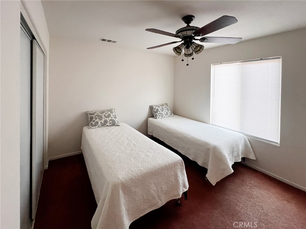 3857 Bella Torre Road Perris, CA 92571 - Photo 15 of 25 a bedroom with two beds and a chandelier