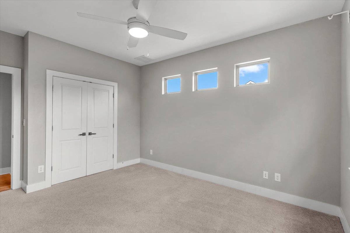 913 Stobaugh Street, Unit B Austin, TX 78757 - Photo 33 of 40 A comfortable 2nd bedroom with a ceiling fan and upper windows offering ample natural light.