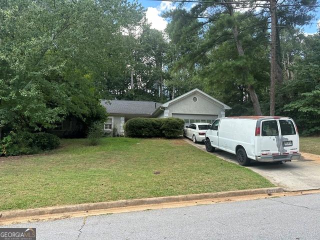 a view of a white house and a yard with garage