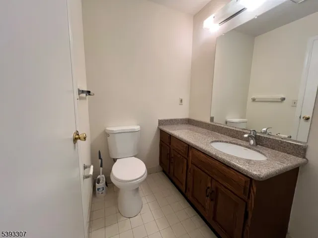 a bathroom with a granite countertop sink toilet and a mirror