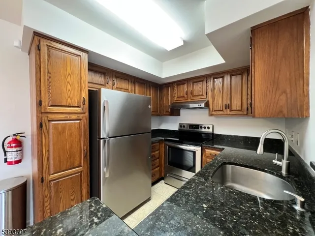 a kitchen with granite countertop stainless steel appliances a refrigerator and a sink