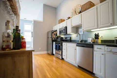 a kitchen with stainless steel appliances granite countertop a refrigerator and a stove top oven