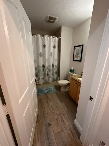 a bathroom with a sink a toilet a window and a shower