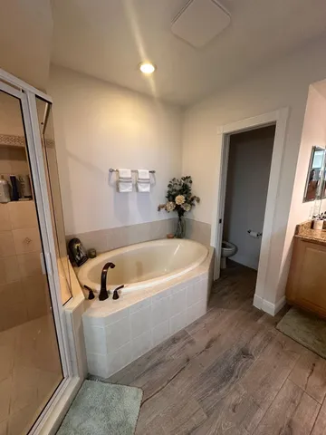 a bathroom with a tub a sink and a large mirror