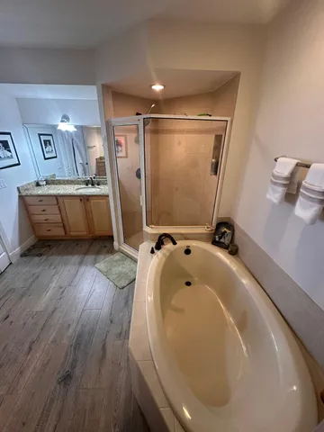 a bathroom with a tub sink and mirror