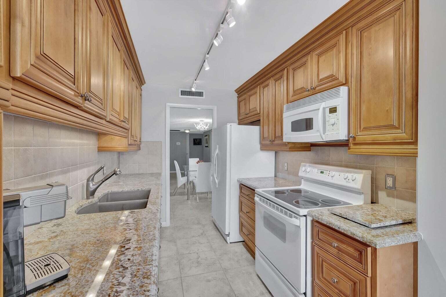 4200 North Ocean Drive, Unit 2201 Singer Island, FL 33404 - Photo 13 of 65 a kitchen that has a sink and a stove