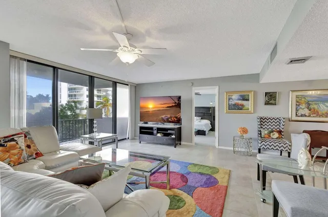 a living room with furniture and a dining table with chairs