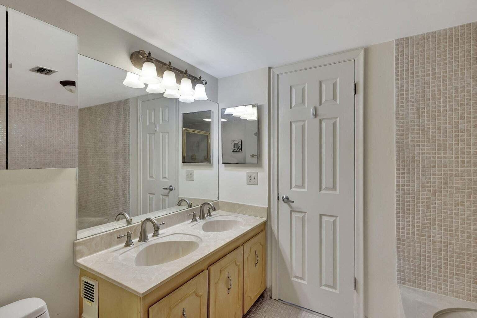 4200 North Ocean Drive, Unit 2201 Singer Island, FL 33404 - Photo 45 of 65 a bathroom with a sink double vanity and a mirror