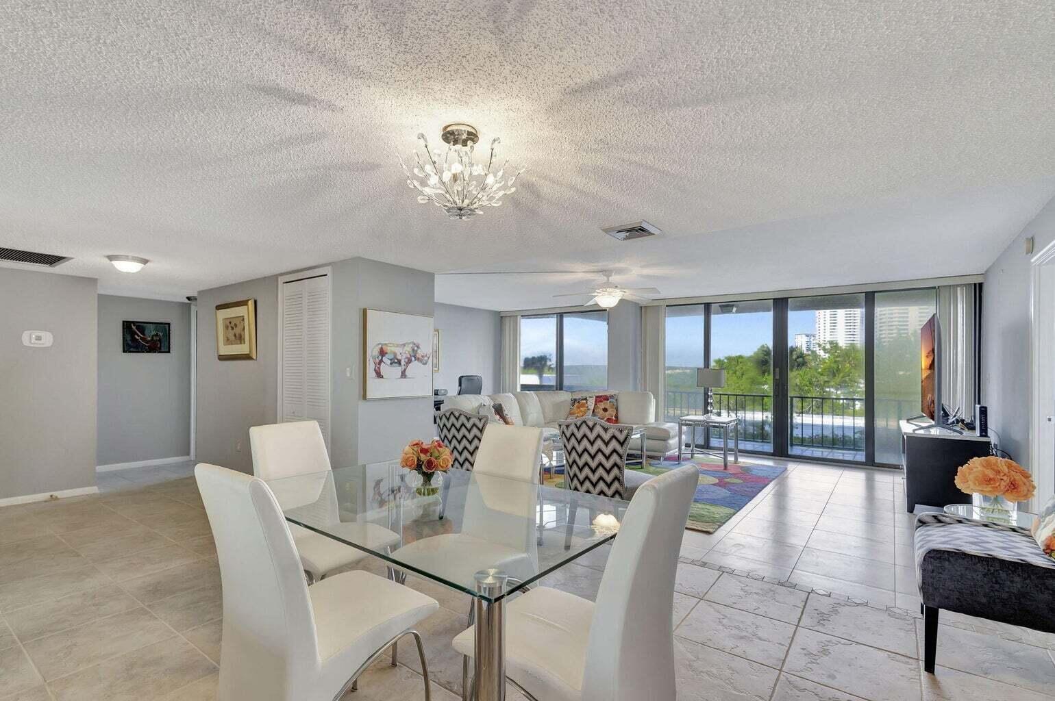 4200 North Ocean Drive, Unit 2201 Singer Island, FL 33404 - Photo 51 of 65 a view of a dining room with furniture large windows and wooden floor