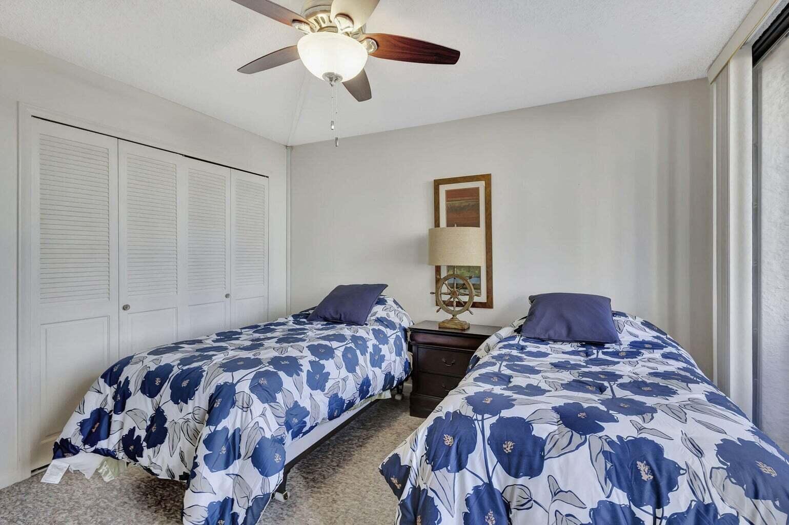 4200 North Ocean Drive, Unit 2201 Singer Island, FL 33404 - Photo 52 of 65 a bedroom with two beds and a chandelier