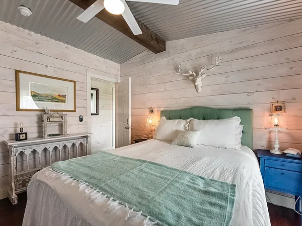 a large bed sitting in a bedroom next to a window