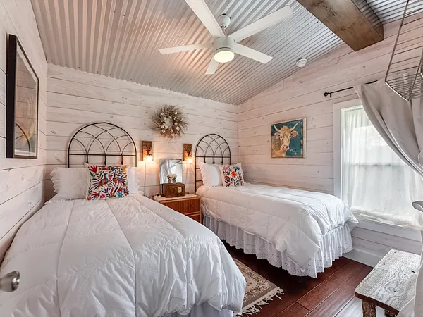 a bedroom with two beds and a window