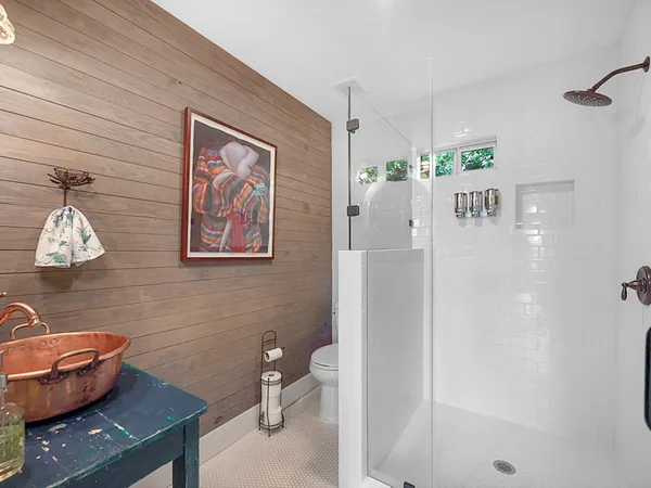 a bathroom with a sink a toilet and shower