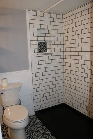 a bathroom with a toilet and a shower