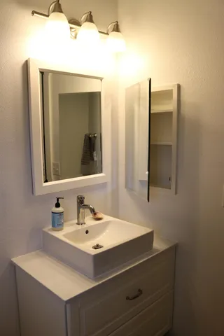a bathroom with a sink vanity and mirror